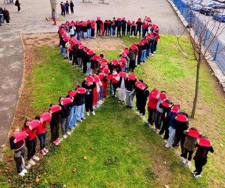 Fresque humaine représentant un ruban rouge, réalisée par les collégiens.